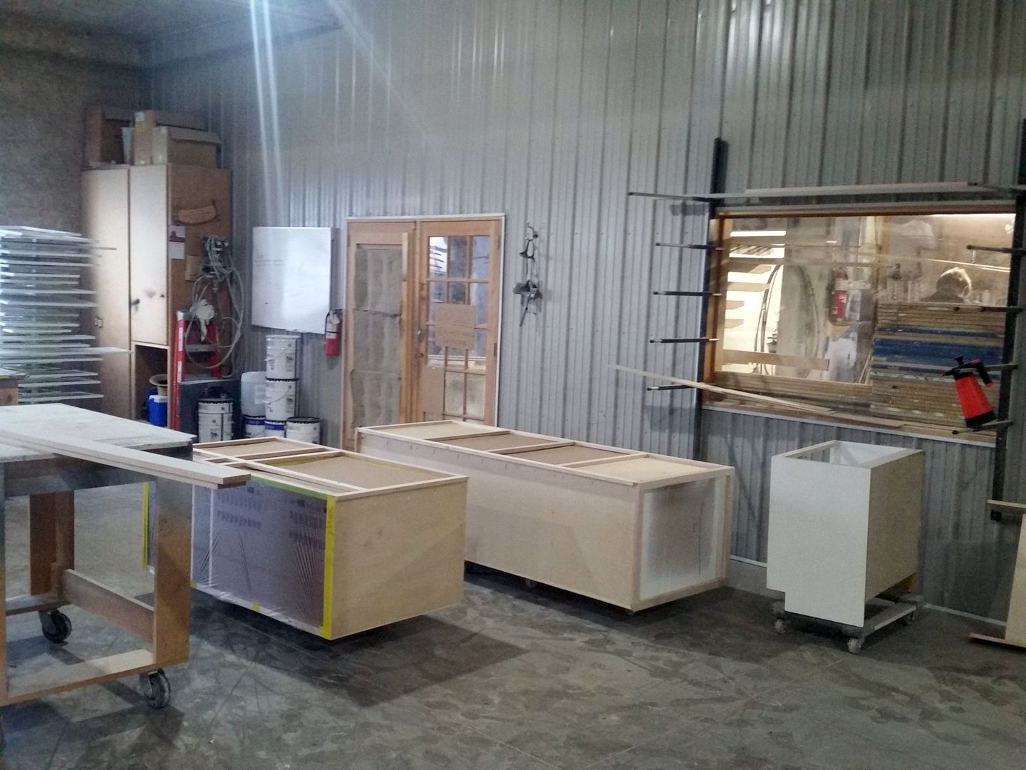 a room filled with lots of wooden boxes and a vacuum cleaner.