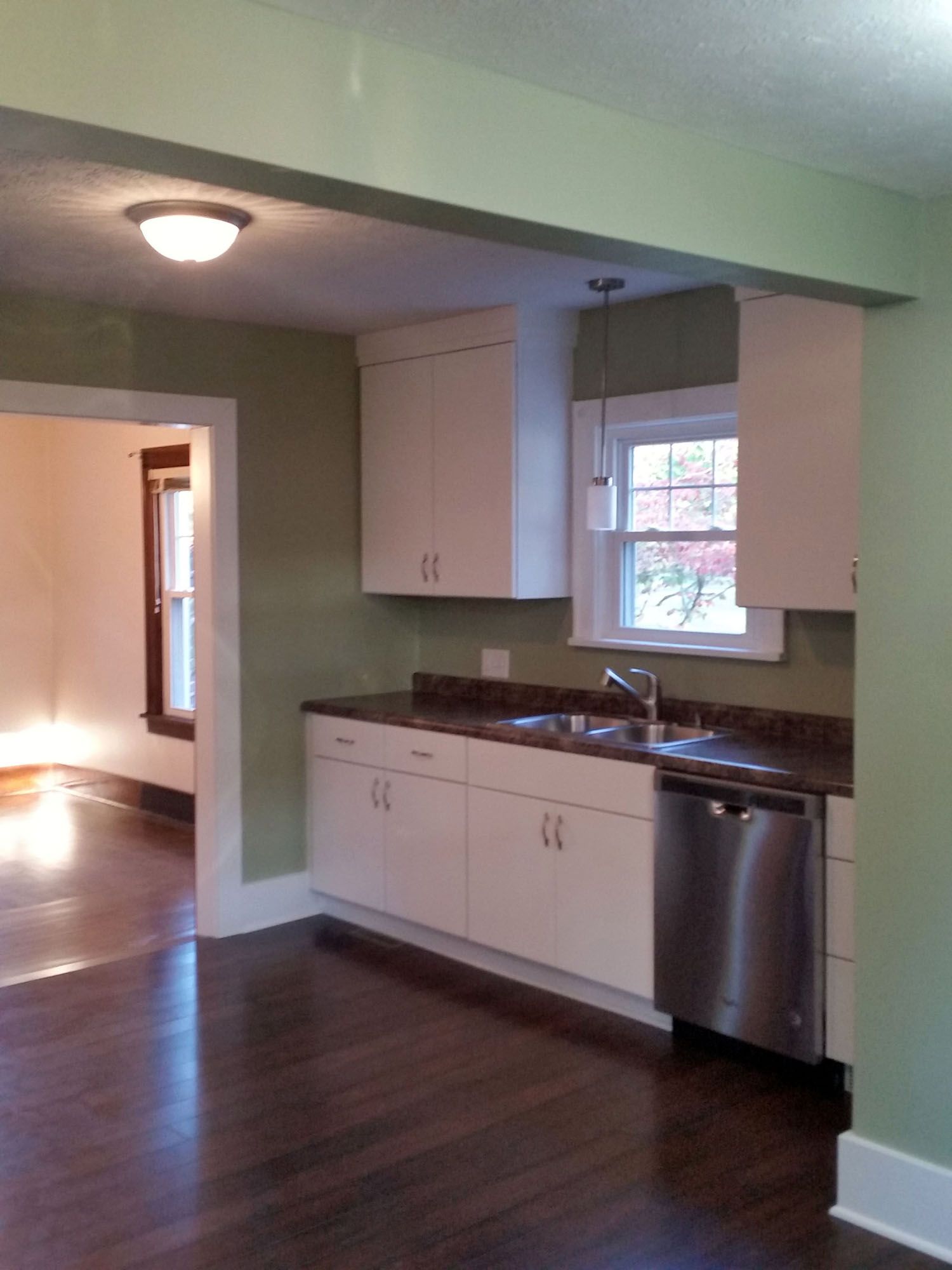 a kitchen with white cabinets and a stainless steel dishwasher Amish Cabinets.