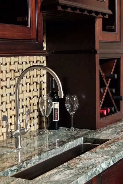 a sink with a bottle of wine and two glasses on it