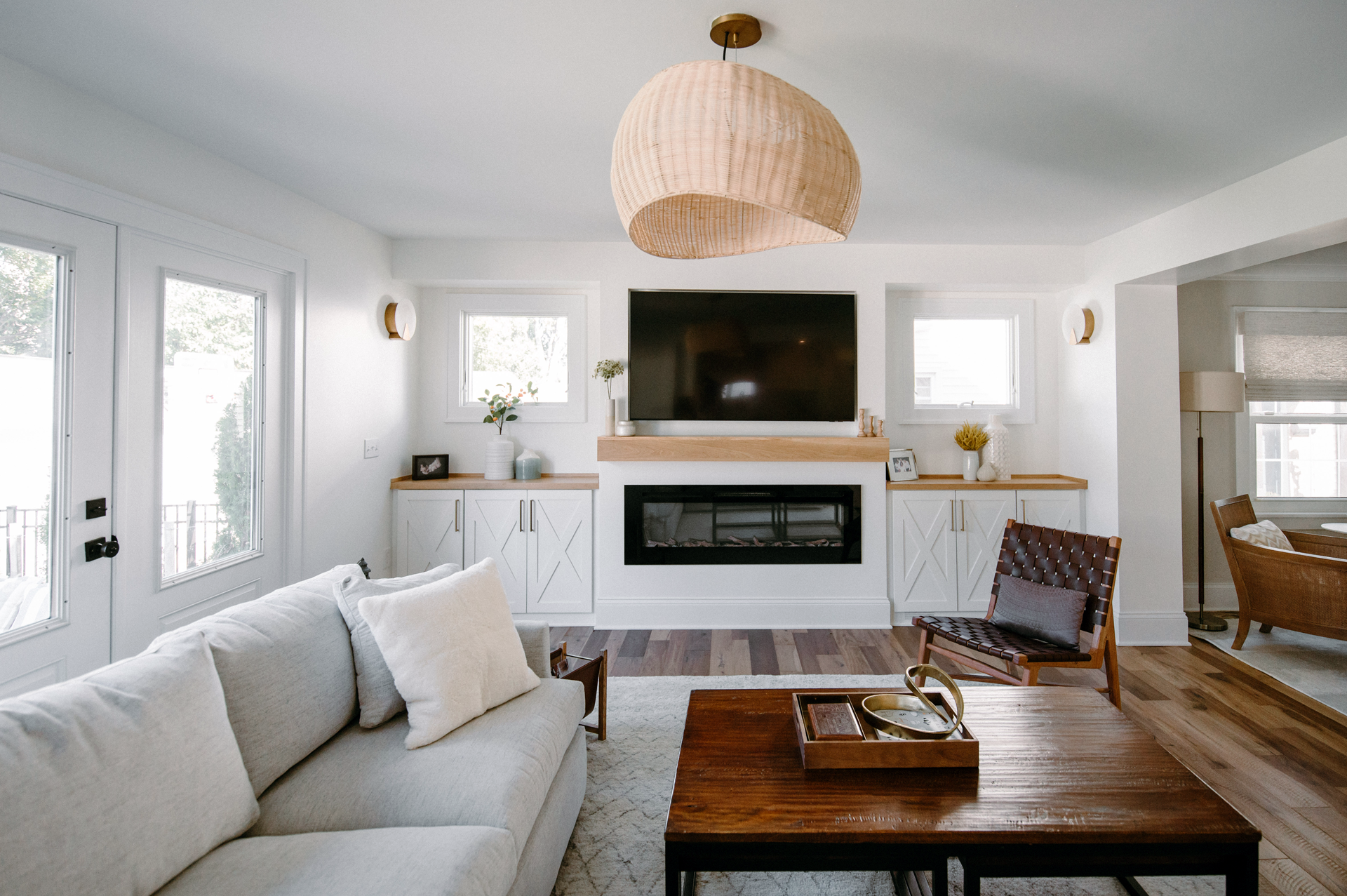 a living room with a couch , coffee table , chair , television and fireplace .