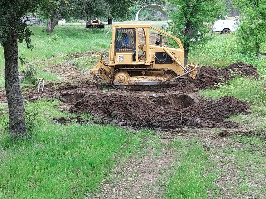 Yellow off-road vehicle driving on a muddy forest path, tilted on uneven ground.