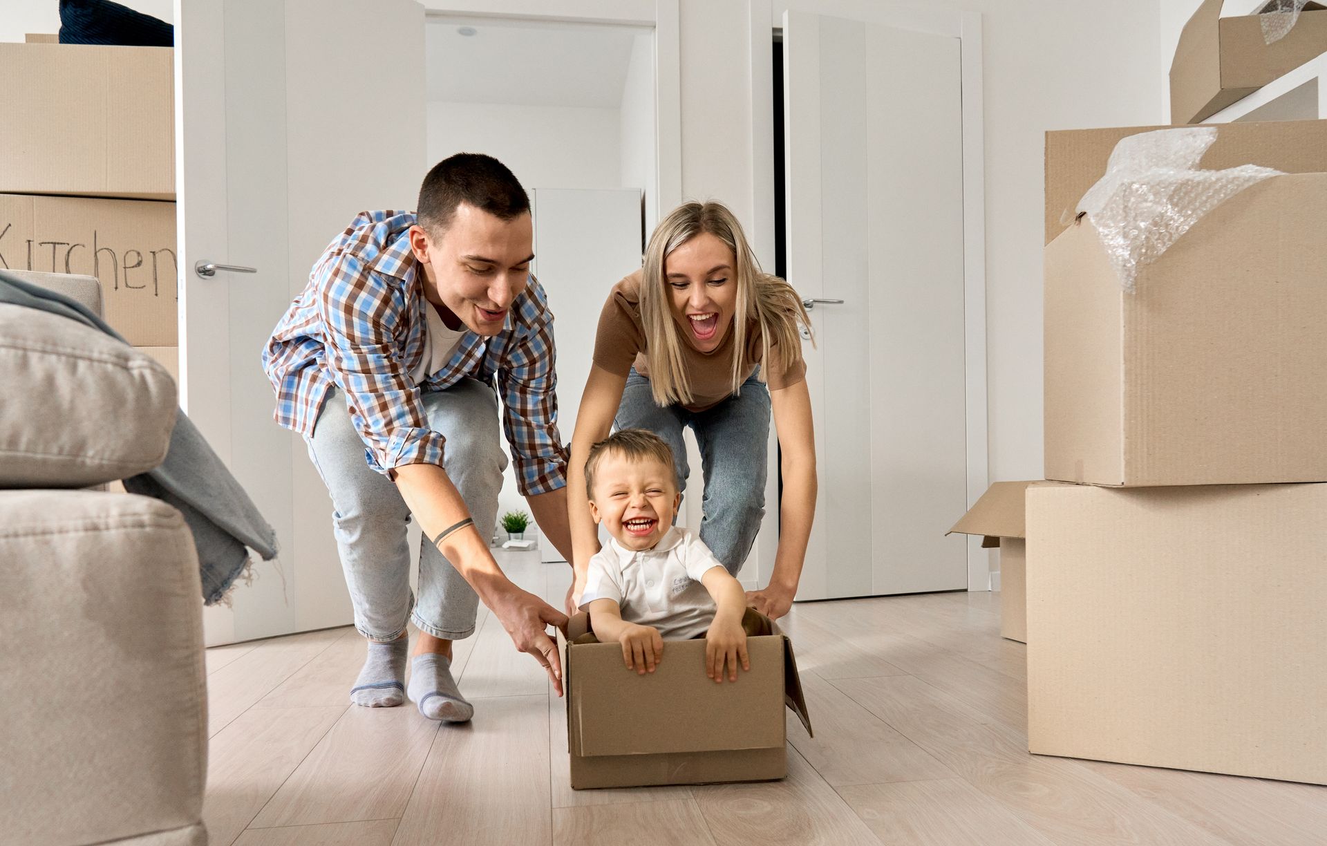 family pushing kid in moving box