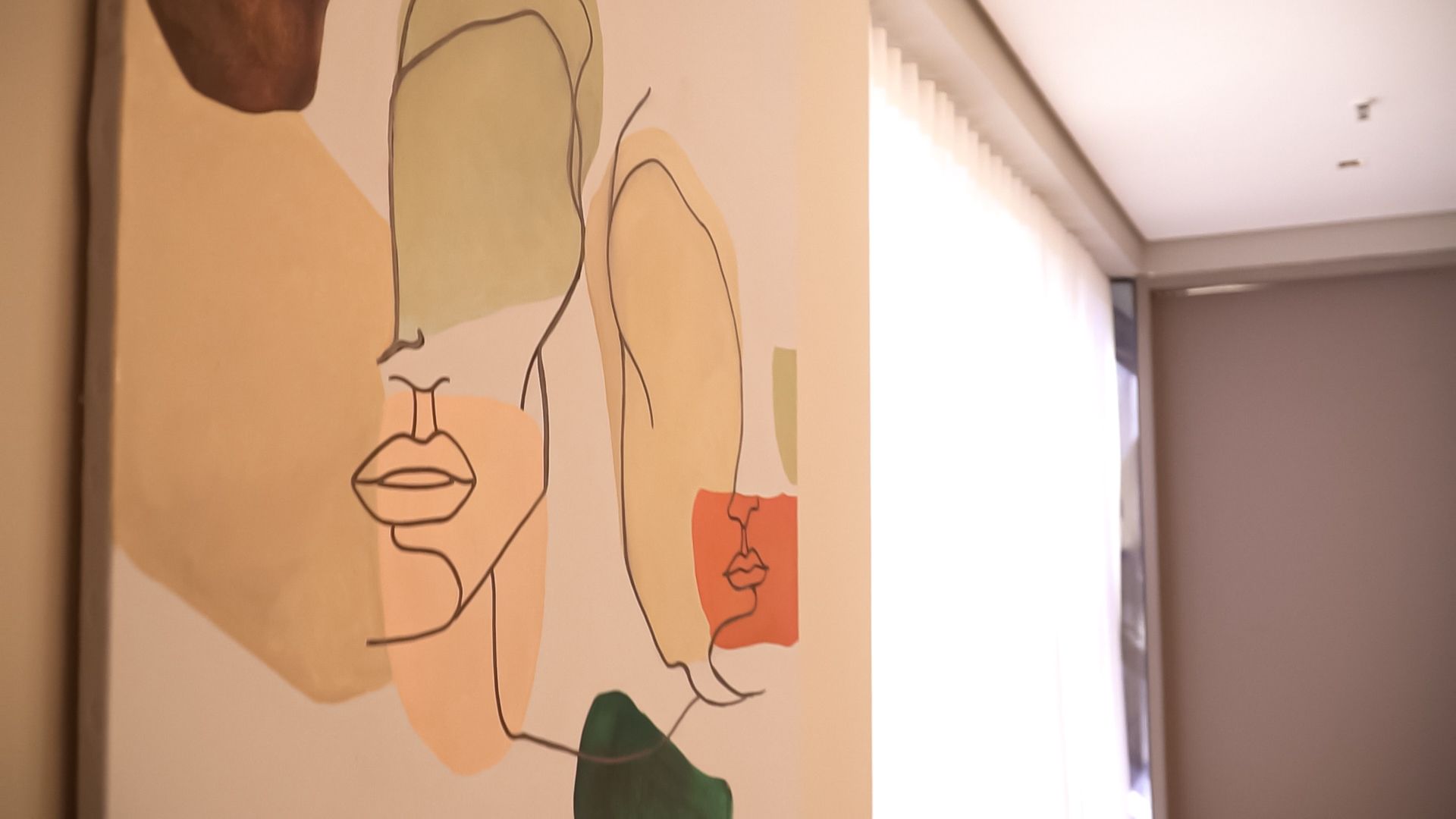 Uma pintura do rosto de uma mulher está pendurada na parede.