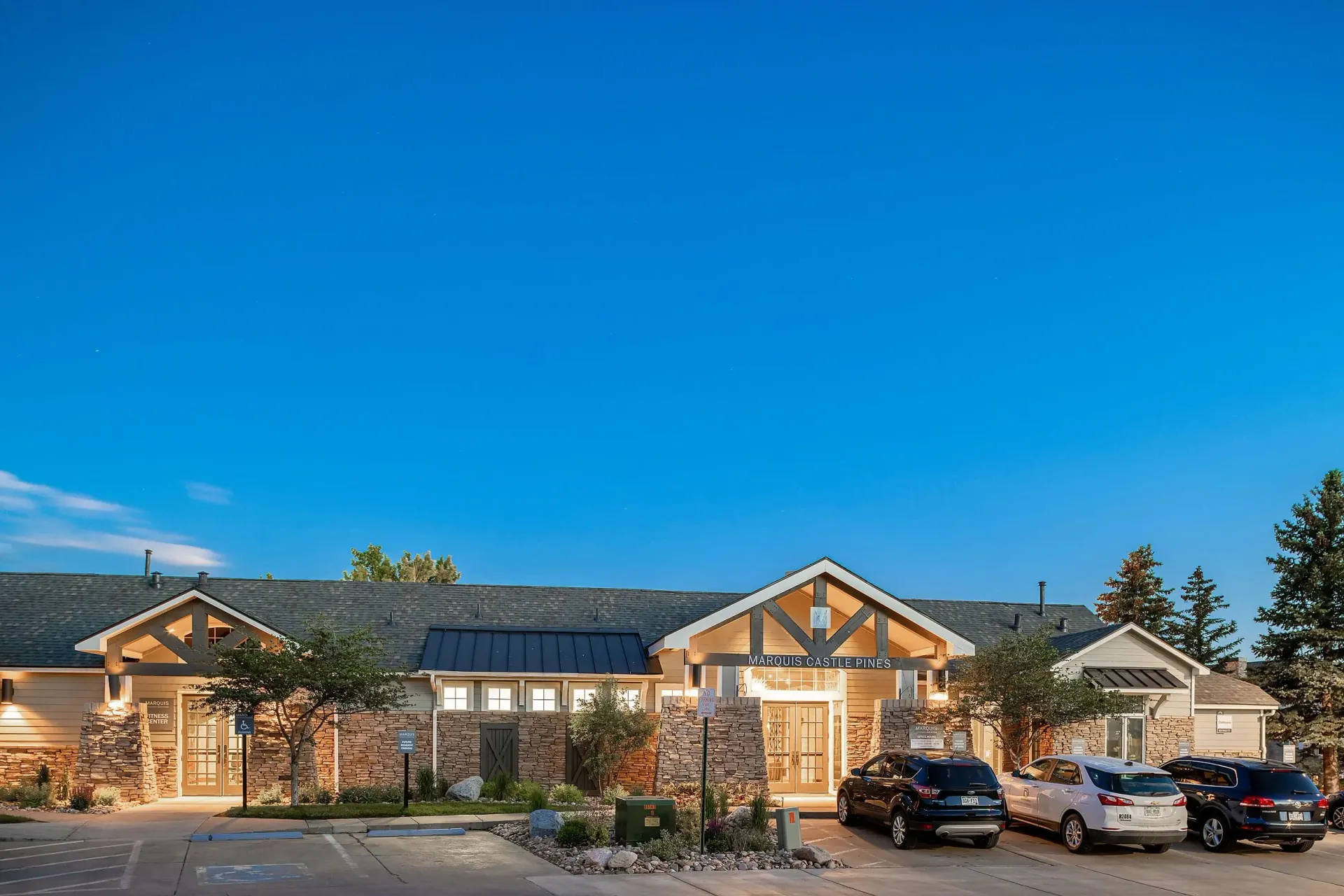 Marquis Castle Pines apartment building exterior with entrance and parking lot.