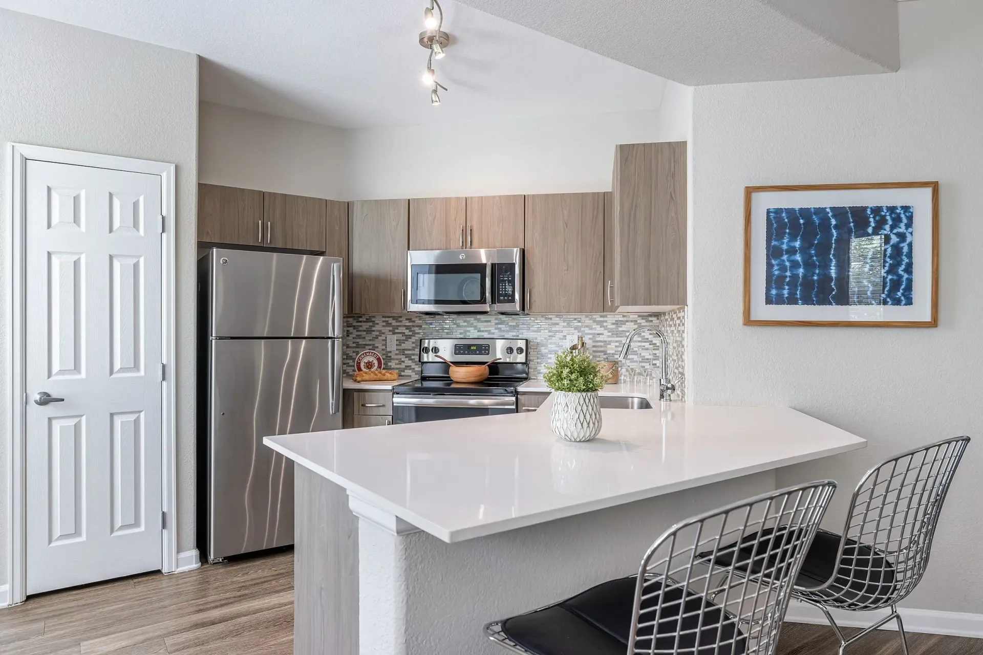 Modern kitchen with stainless steel appliances, granite countertops, and a breakfast bar.
