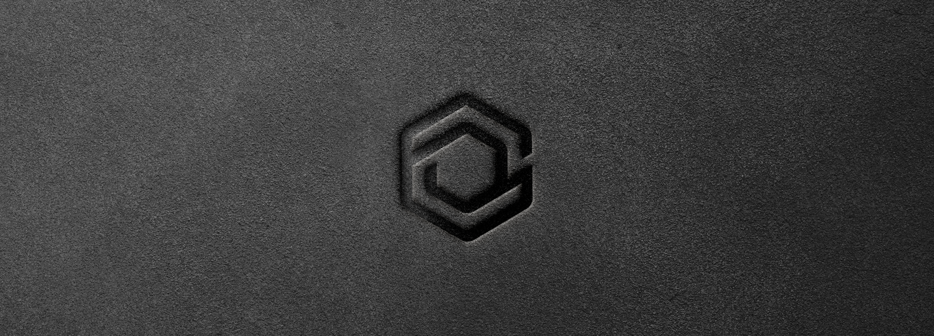 A close up of a black logo on a black surface.