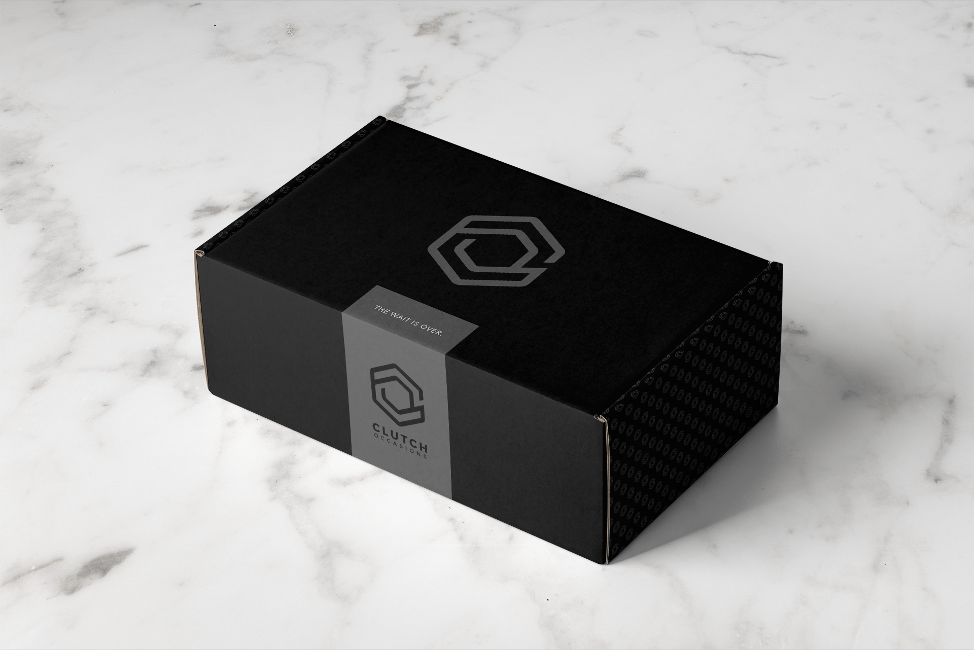 A black box with a logo on it is sitting on a marble surface.
