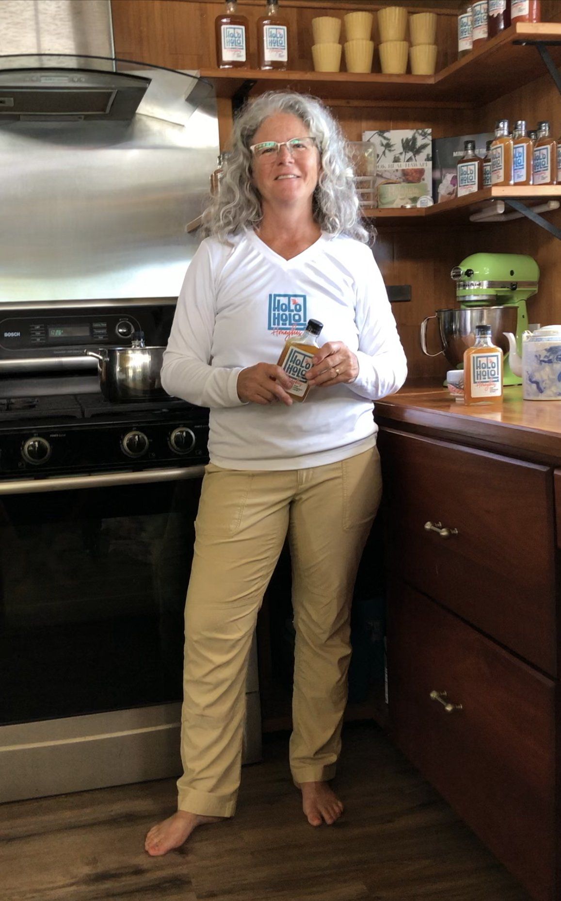 A woman is standing in a kitchen holding a bag of food.