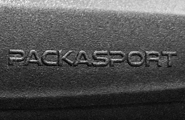 A black and white photo of the word packasport on a metal surface.