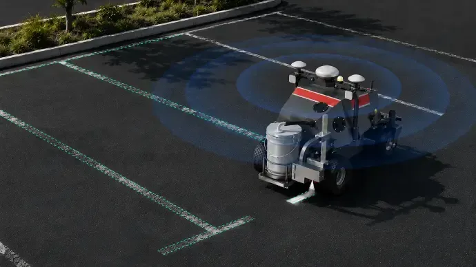 Small robotic vehicle with blue scanning arcs moving across an empty asphalt parking lot