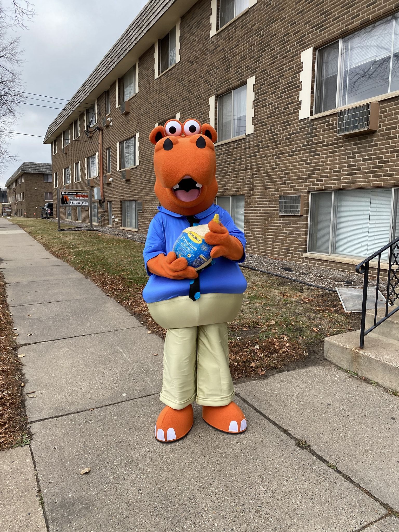 Housing Hub Mascot, Hubbs ,holding frozen turkey.