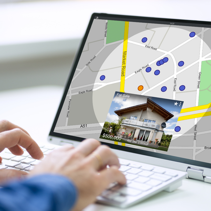 Person using laptop with real estate map, house photo overlay, and cursor.