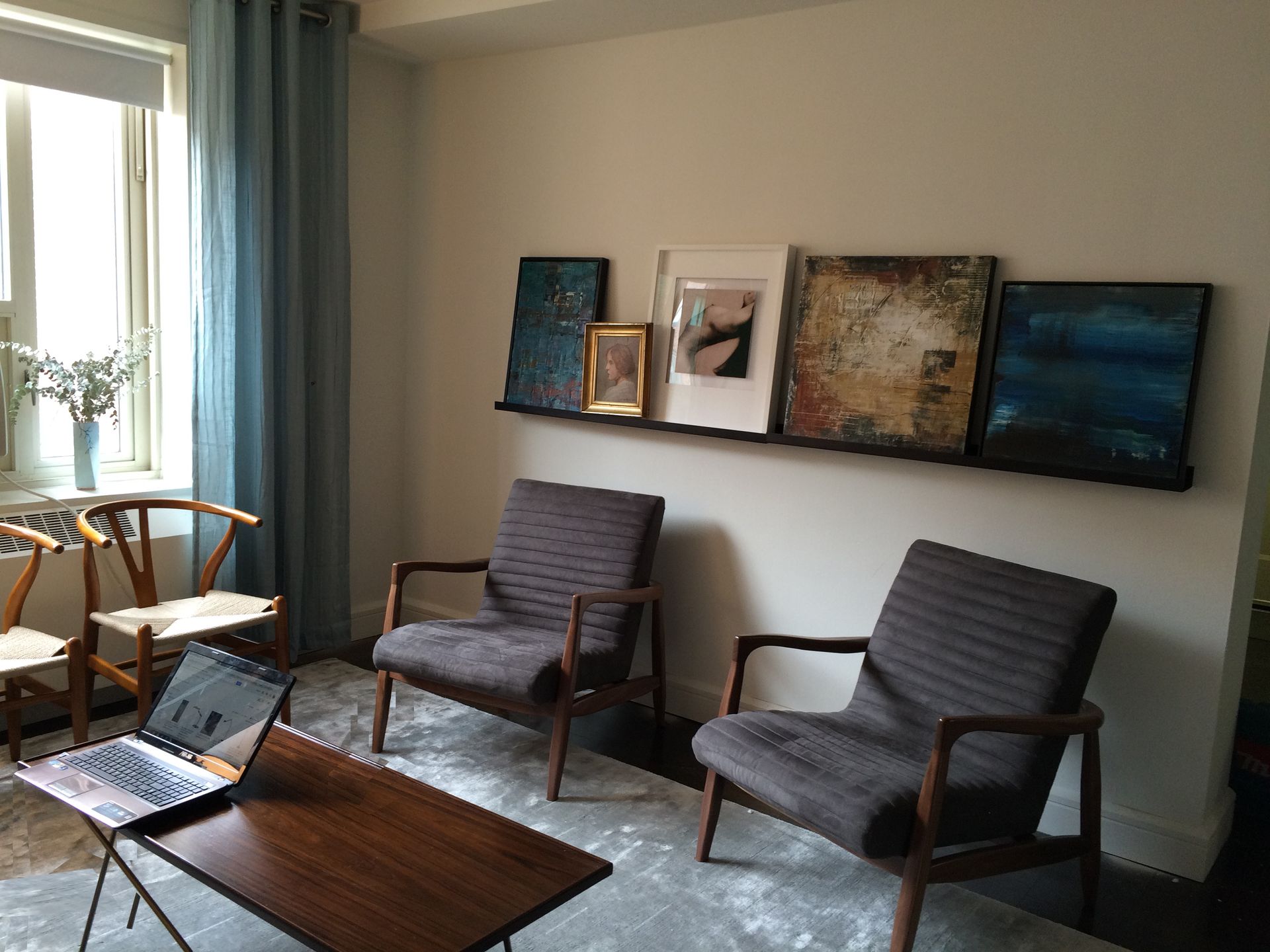 Living Room with Cozy sitting area with two chairs, blue curtains, and framed artwork on the wall