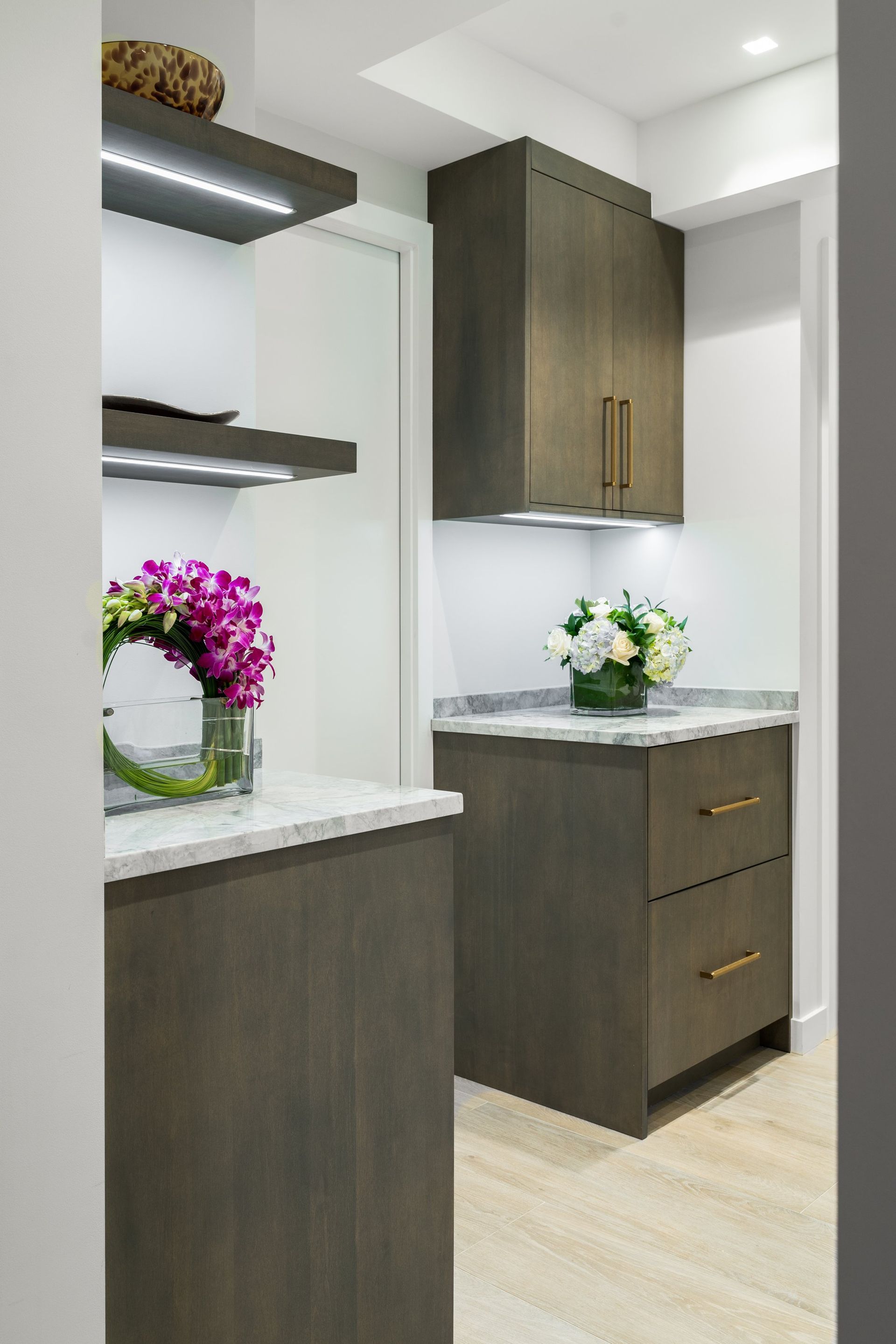 Kitchen walk-in Pantry with white and wood cabinetry, black trim, and modern lighting