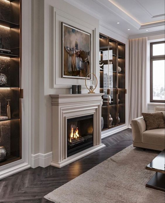Elegant room with framed artwork, built-in shelving, soft lighting, and tall window