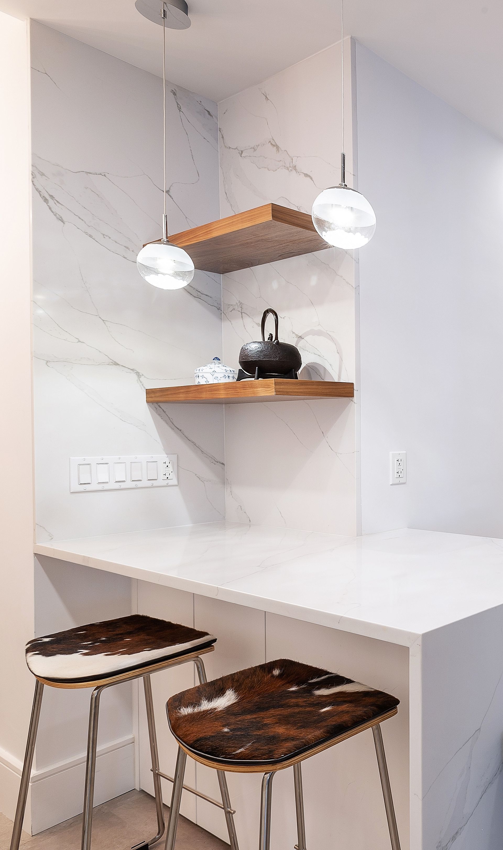 Marble kitchen wall with wood floating shelf and modern pendant light