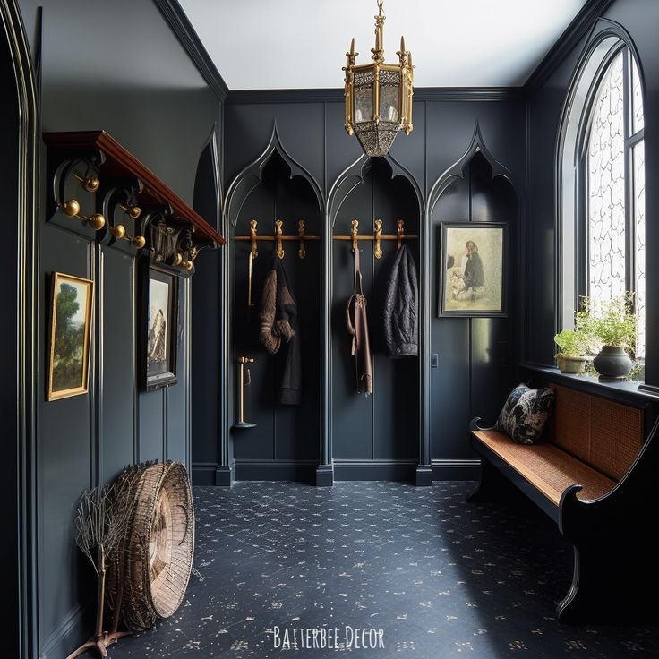 Dark mudroom with arched window, storage hooks, chandelier, and dramatic wall color