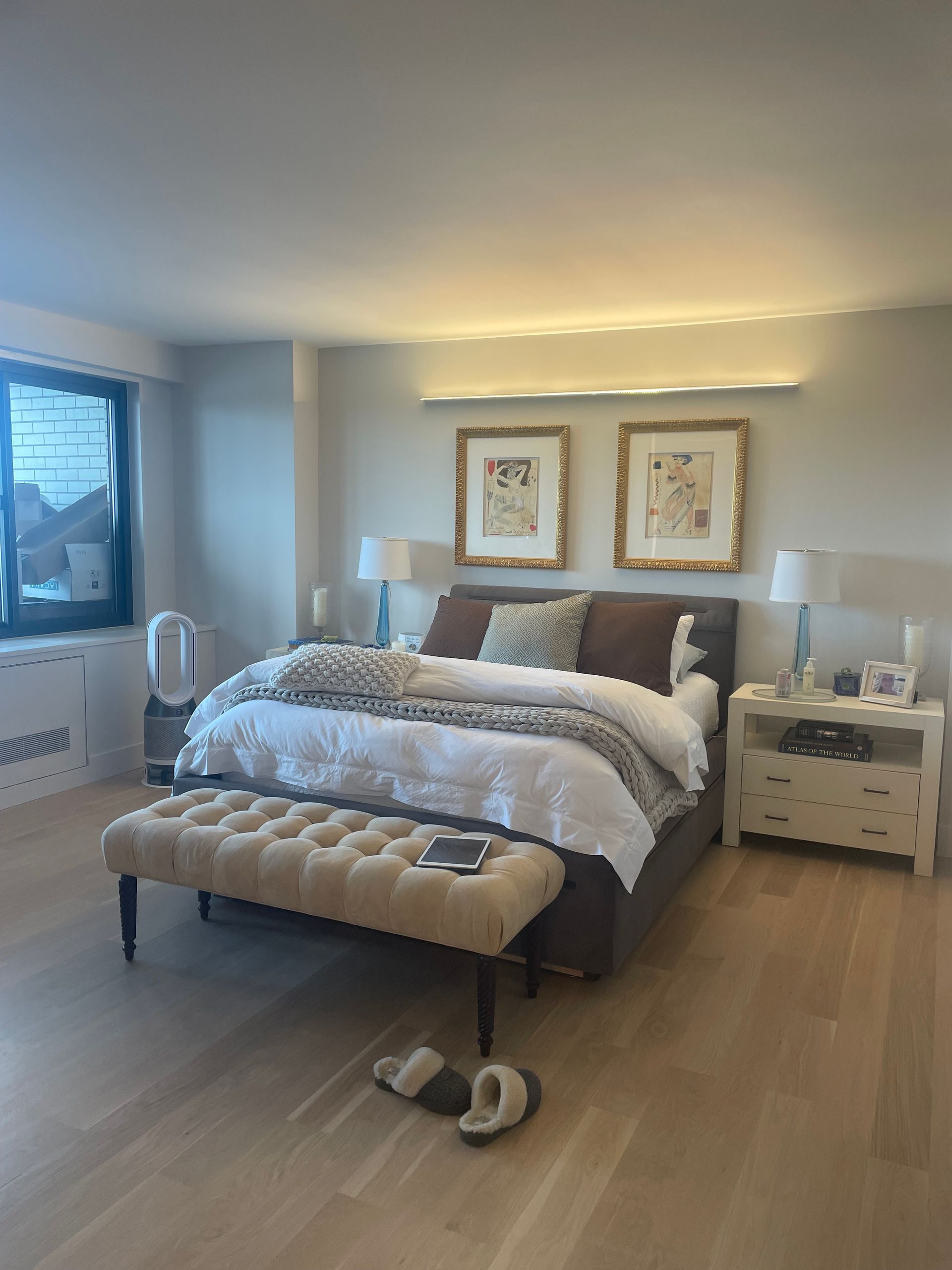 Minimal interior wall with framed artwork, soft lighting, and modern ceiling fixture