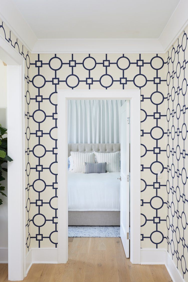 Hallway  wall with blue geometric wallpaper, mirror, and clean modern trim