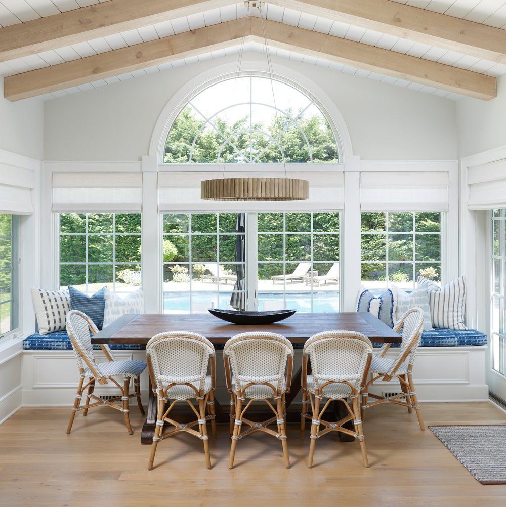 Kitchen dining area with Bright vaulted room with arched window, exposed beams, and modern chandelier