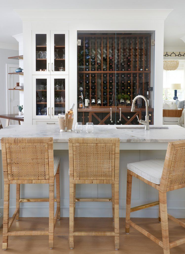 Built-in kitchen wine storage with glass cabinets, white trim, and open shelves