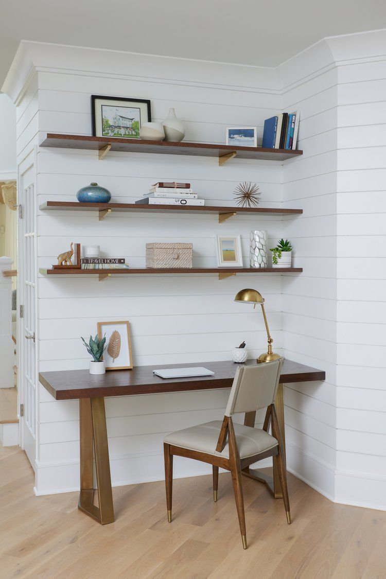 Home Office area with White shiplap wall with floating shelves, books, artwork, and coastal décor