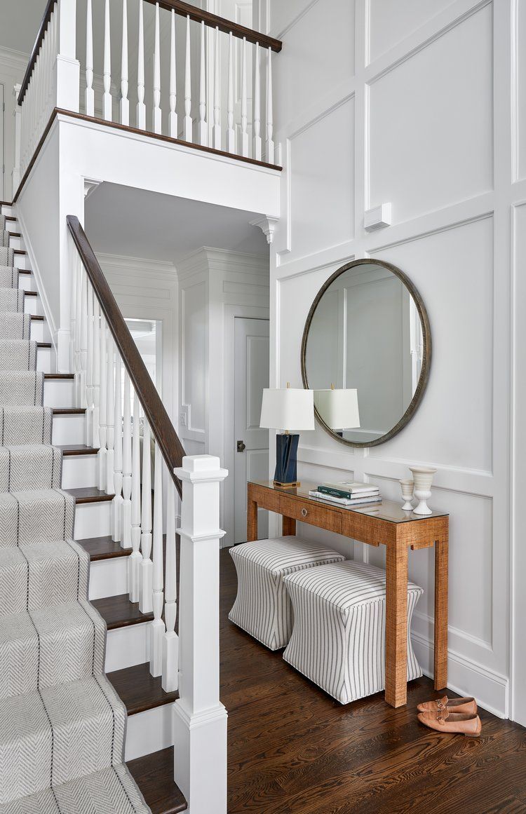 Foyer with White staircase and balcony railing with paneled walls and classic interior trim