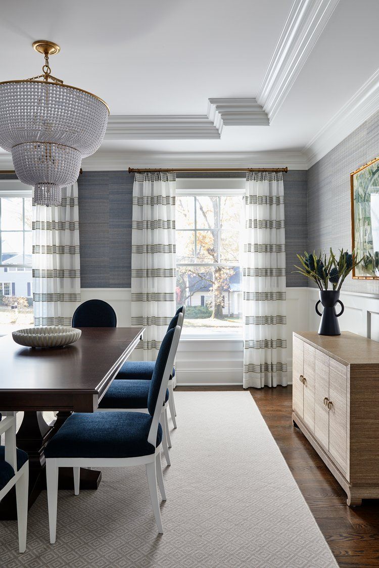 Beaded chandelier and detailed crown molding in an elegant dining room, with drapery window treatments 