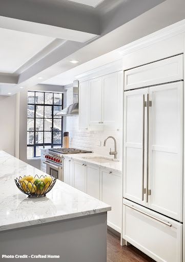 White kitchen ceiling and cabinetry detail with coffered beams and modern finishes