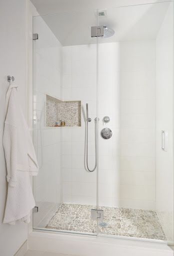 Bright bathroom with glass enclosed shower, and wall niche