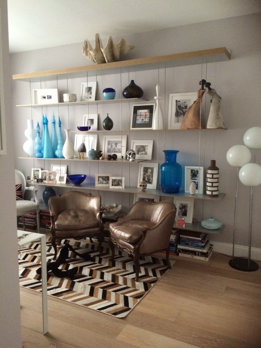 Home Office Built-in wall shelving with decorative objects, books, artwork, and display lighting 