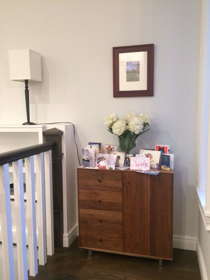 Minimal interior wall with table lamp, framed artwork, and white flowers