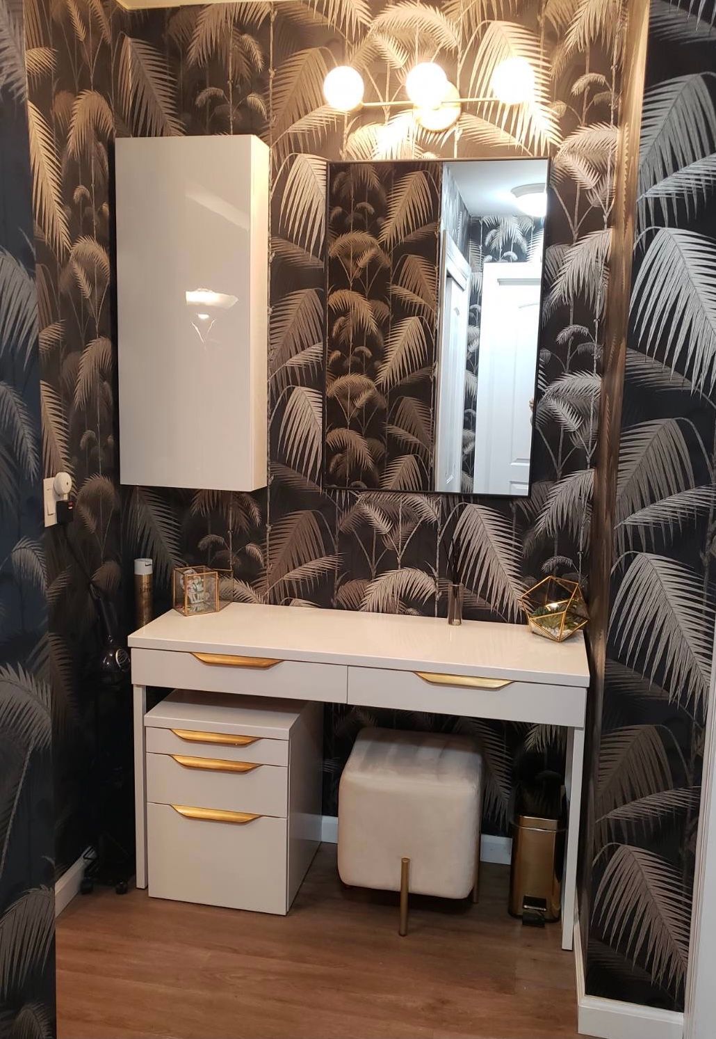 Make-up Vanity Area with tropical wallpaper, mirror, white cabinet, and multi-light wall fixture