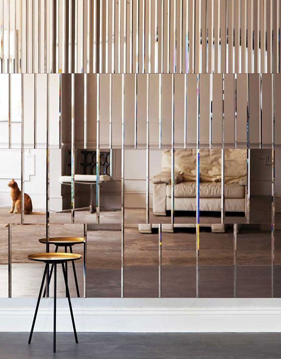 Vertical mirror slat room divider with fireplace and soft natural light