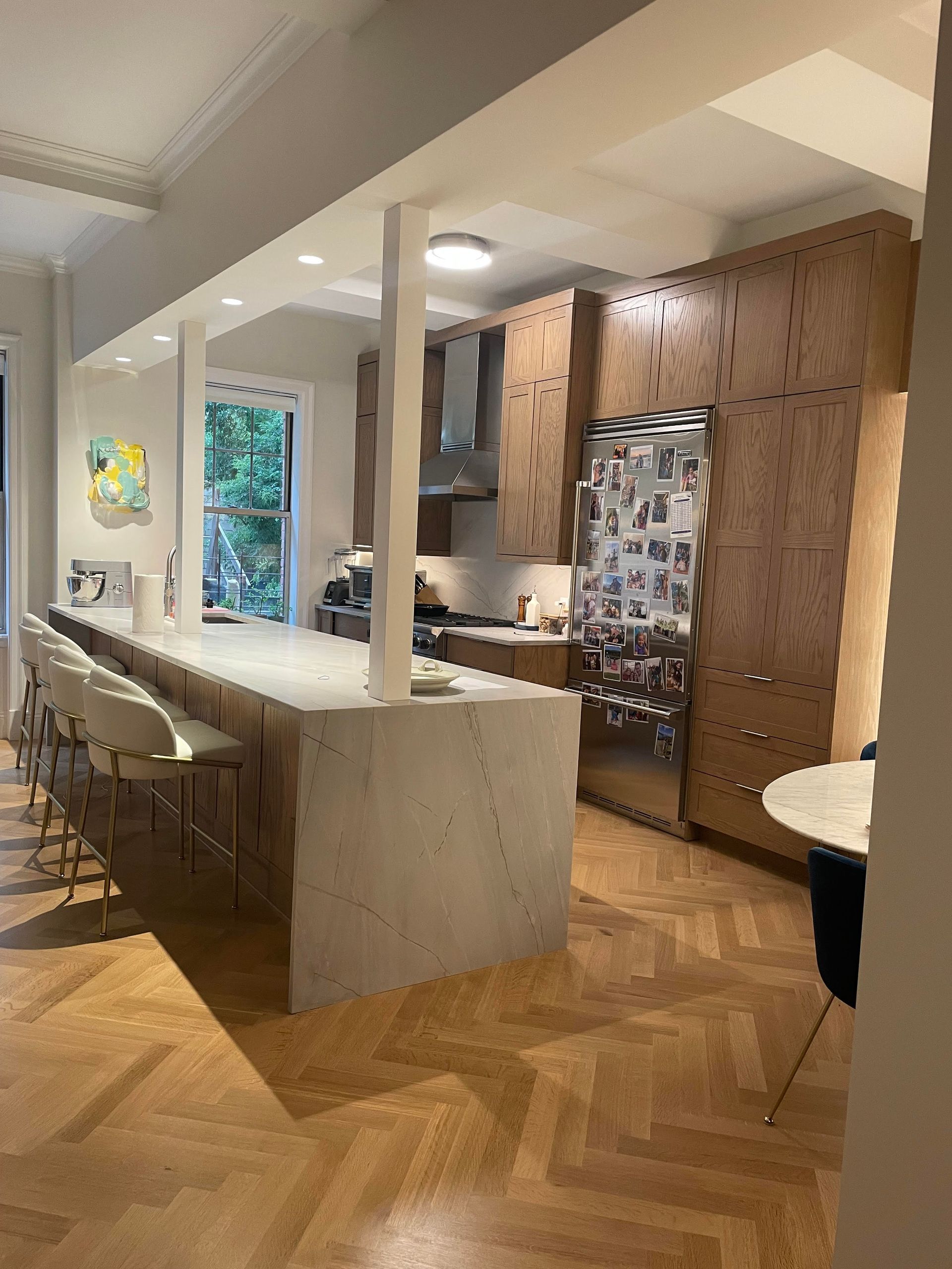 Kitchen with wood cabinetry, white ceiling beams, recessed lighting, and open layout