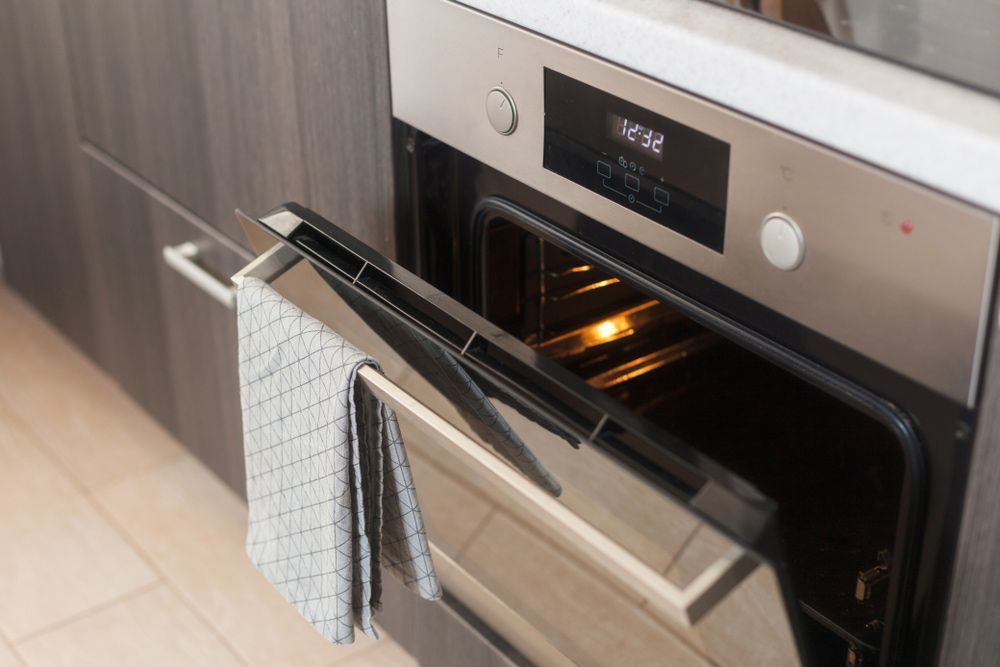 A Stainless Steel Oven With The Door Open And A Towel Hanging On Handle — Appliance City in Wauchope, NSW