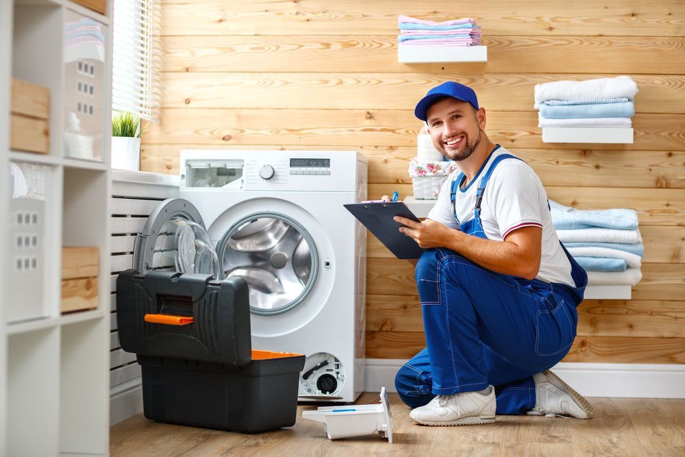 A Man Is Kneeling Down In Front Of A Washing Machine While Holding A Clipboard — Appliance City in Port Macquarie, NSW