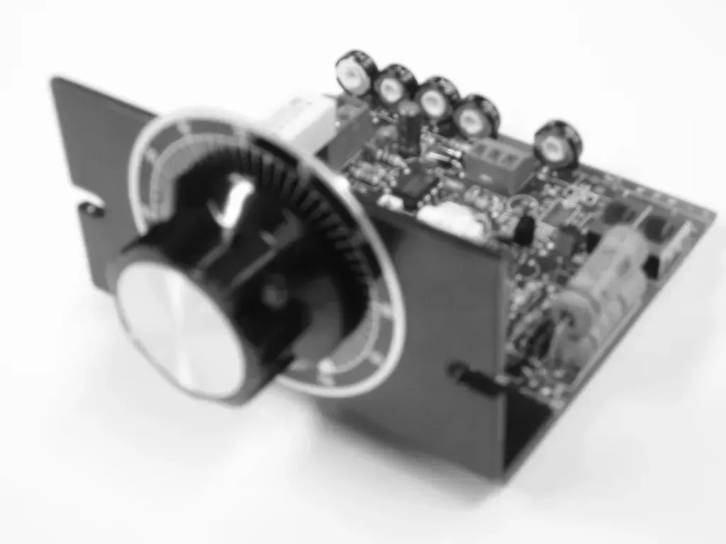 A black and white photo of a knob on top of a circuit board