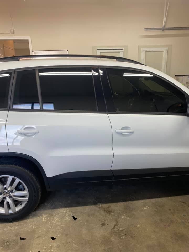 White SUV with tinted windows parked inside a garage.