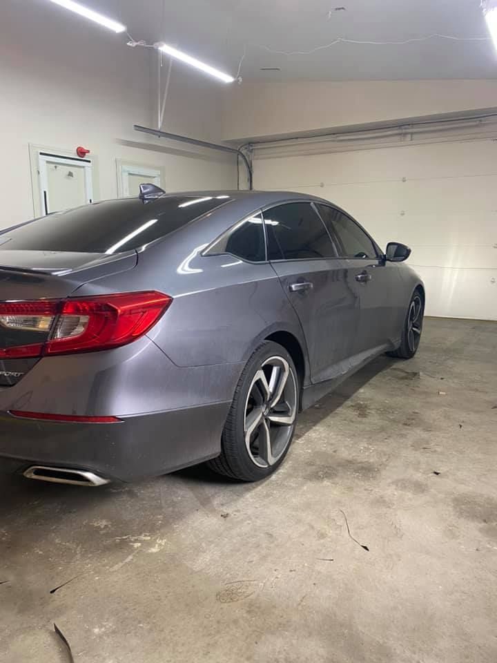 A gray Honda Accord parked inside a garage. The car has tinted windows and silver rims.