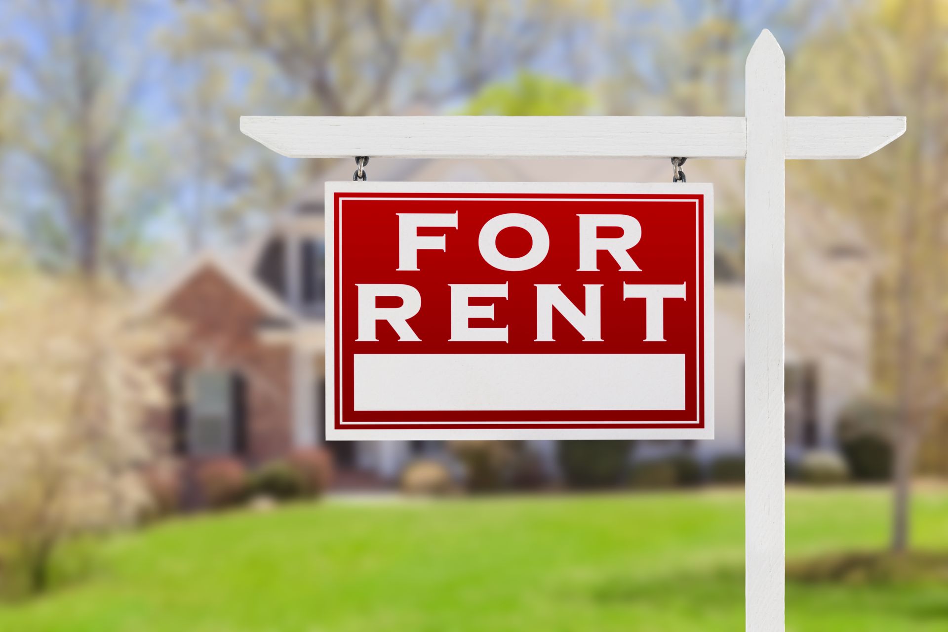 For rent sign stands in front of a house.