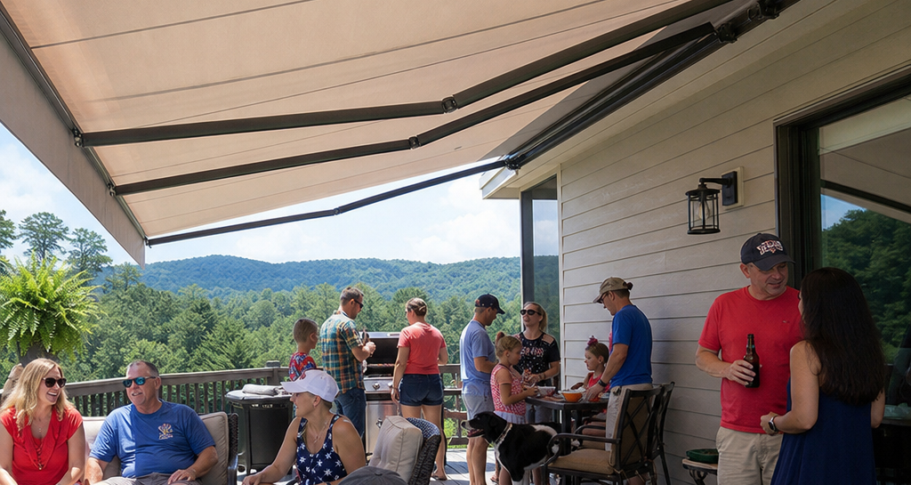 People gathered on a patio under an awning, socializing with mountains visible in the background.