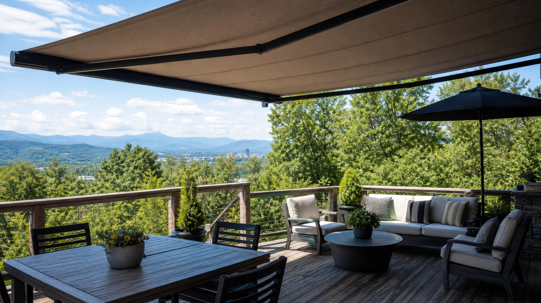 Patio with lounge seating under tan awnings overlooking a green valley and mountains