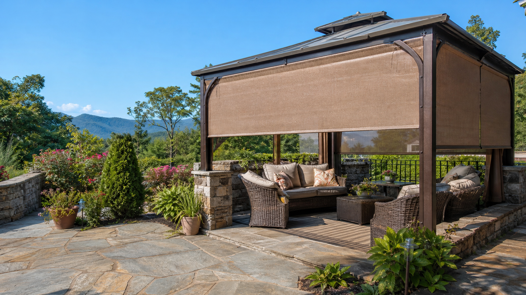 Outdoor stone patio gazebo with woven seating, exterior patio shades, and potted plants overlooking a scenic view