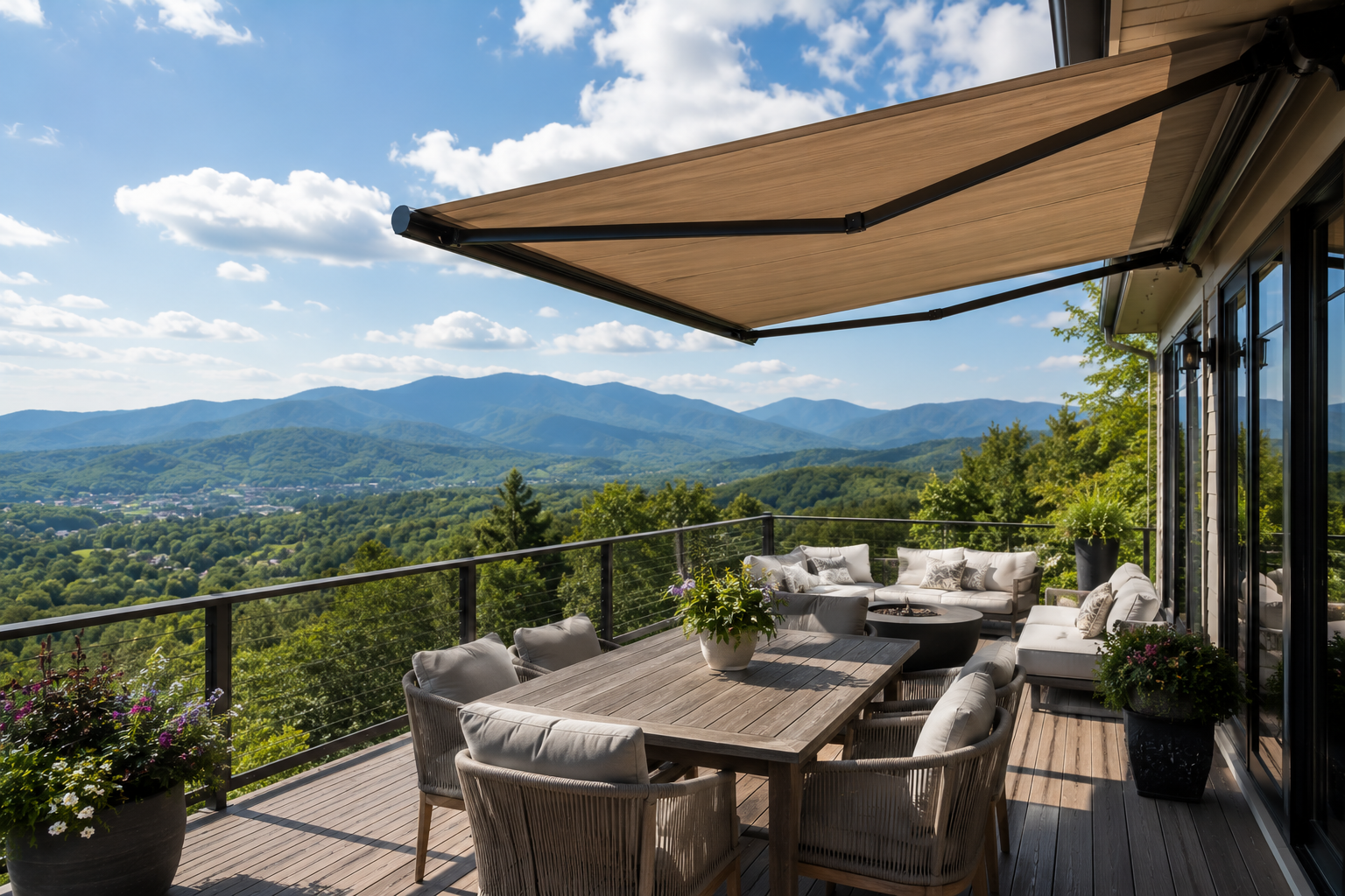 Outdoor patio dining area with wicker chairs, mountain views, and a retractable awning under a blue sky