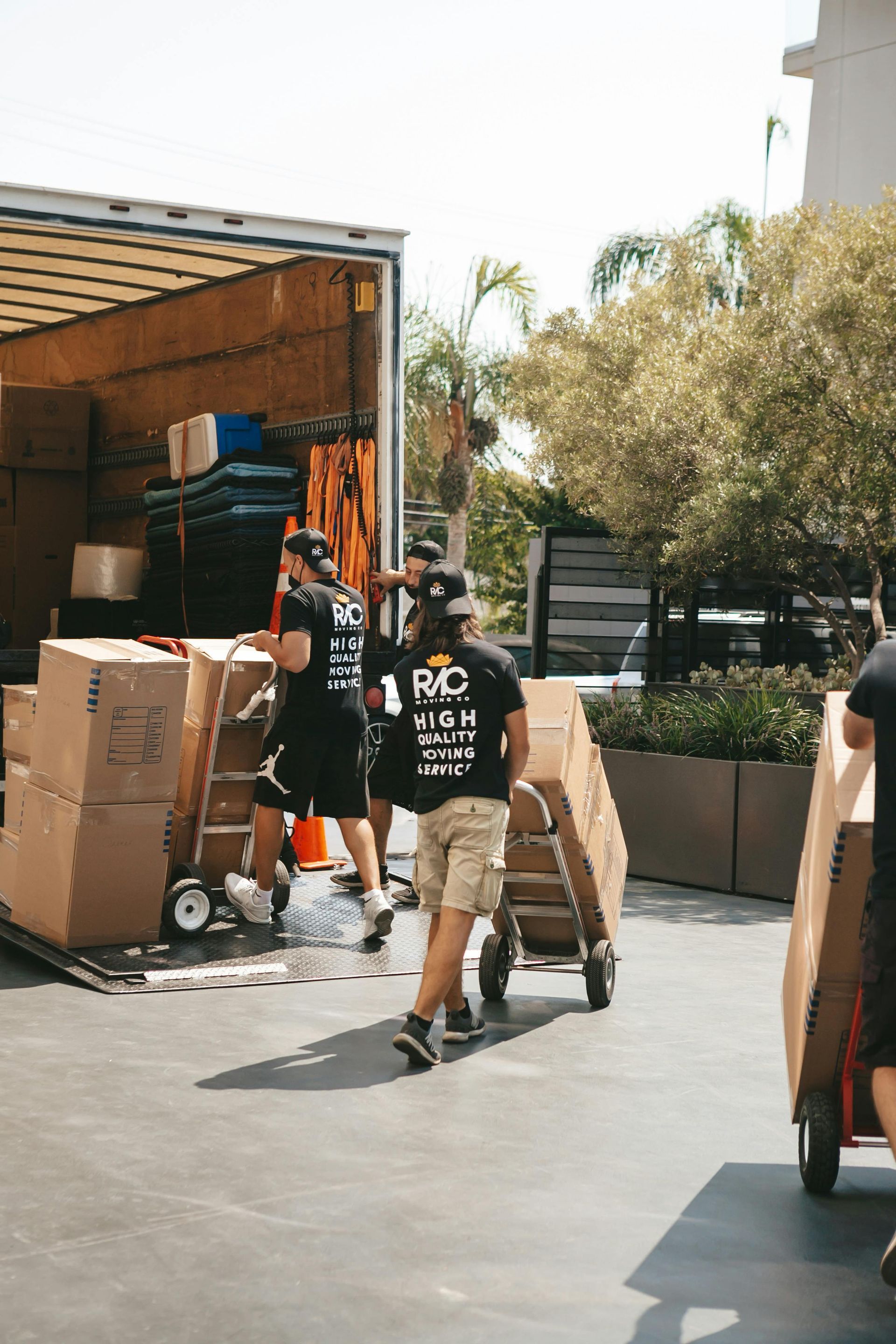 Professional movers using equipment to move boxes onto a truck