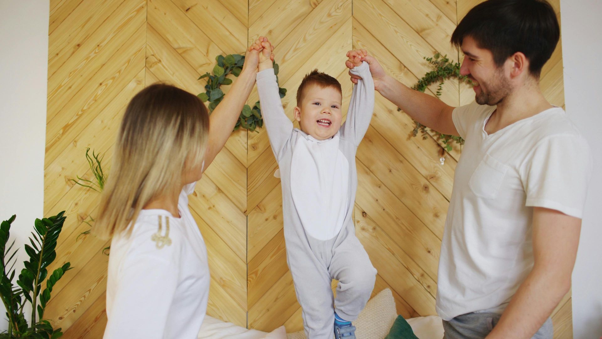 Family celebrating a child with arms raised in a bright wood-paneled room