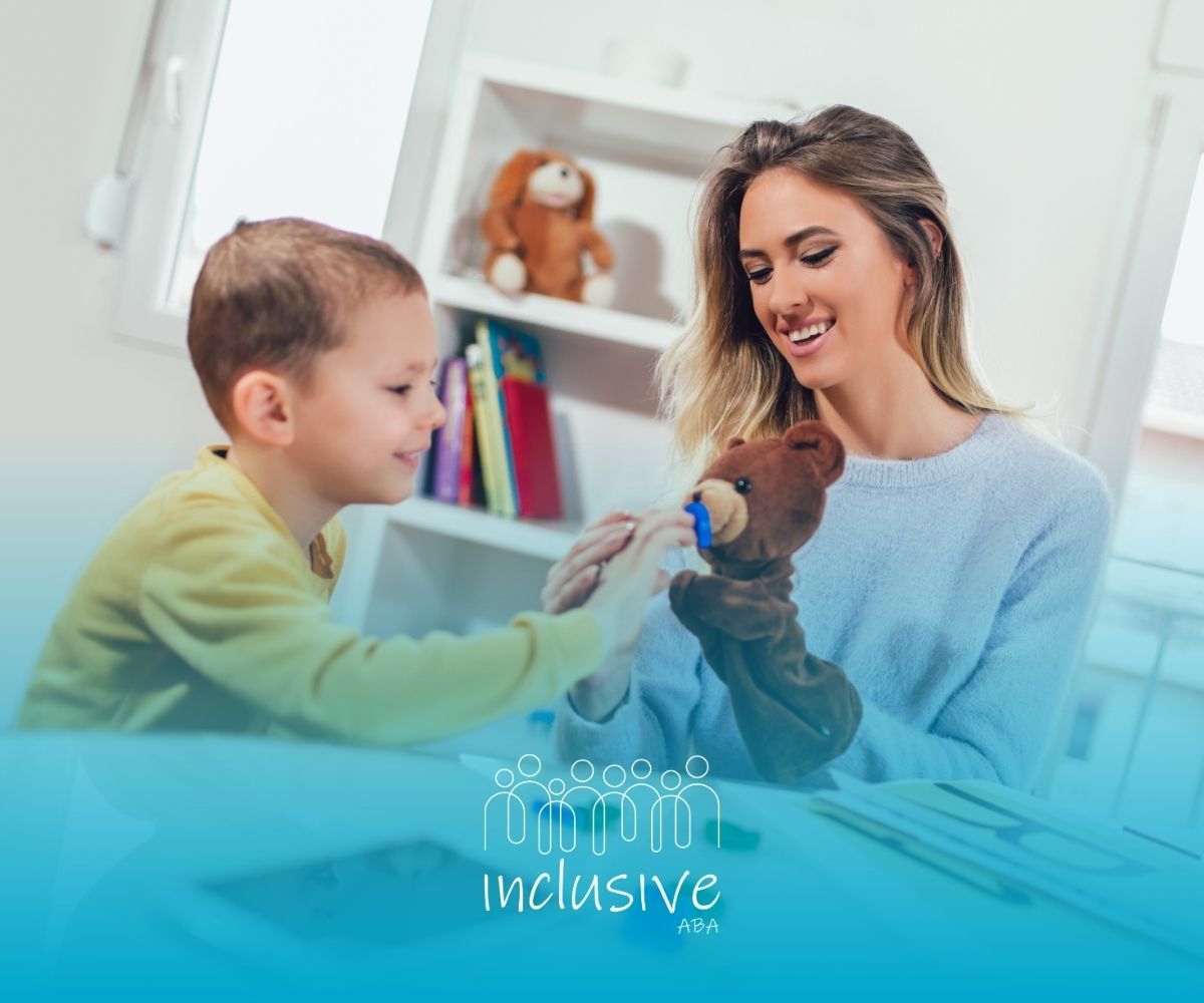 ABA therapist and child playing with a teddy bear at a table in a bright room
