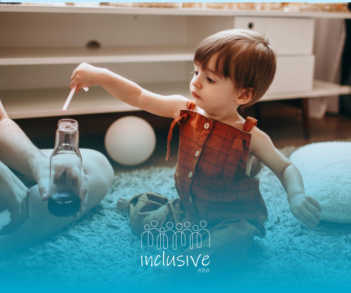 Toddler in rust-colored overalls reaches into a jar while sitting on a carpet in a cozy living room.