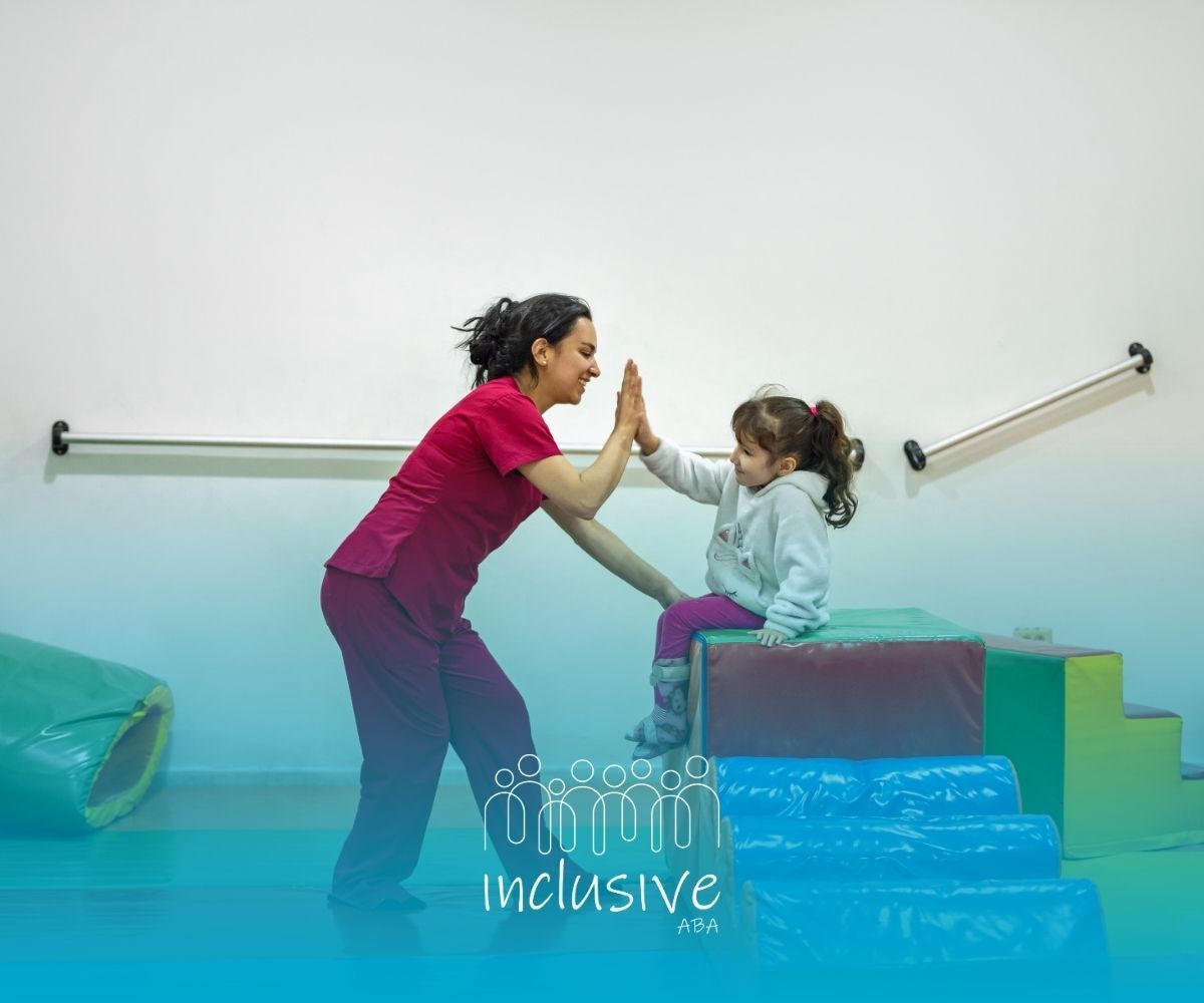 Two people high-five on a stair ramp in a bright therapy room, with “inclusive” text overlay.